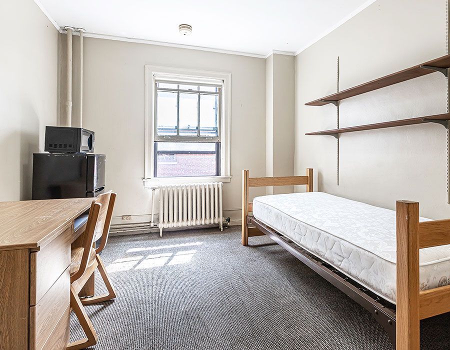 A bedroom with a bed , desk , chair and television.