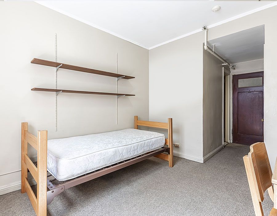 There is a single bed in the middle of the room.