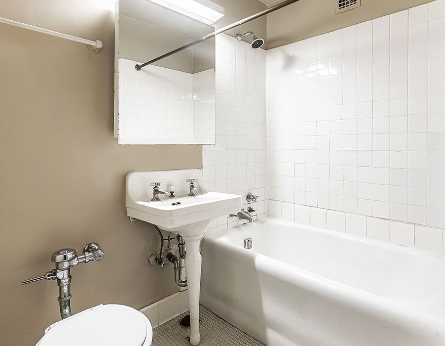 A bathroom with a sink , toilet , bathtub and mirror.