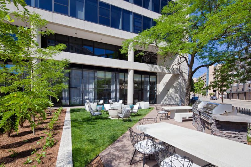 A large building with tables and chairs in front of it.