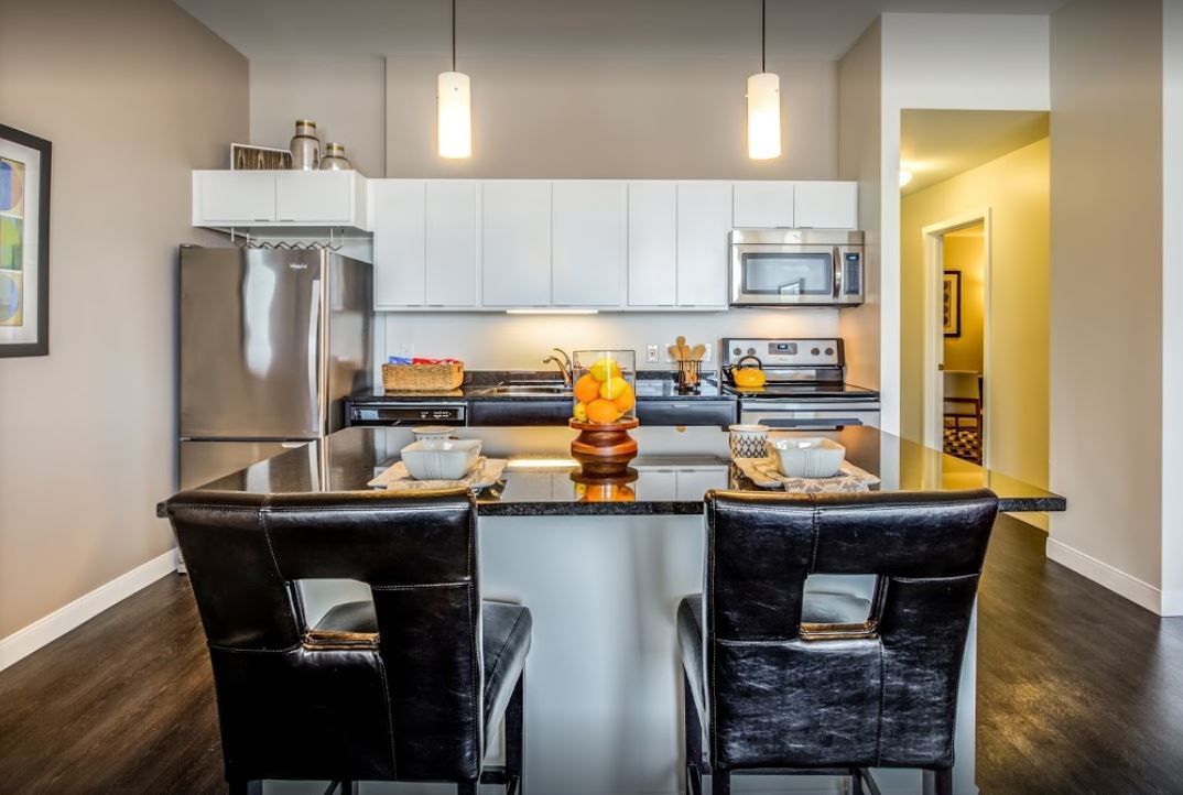 A kitchen with a stainless steel refrigerator , stove , microwave and sink.