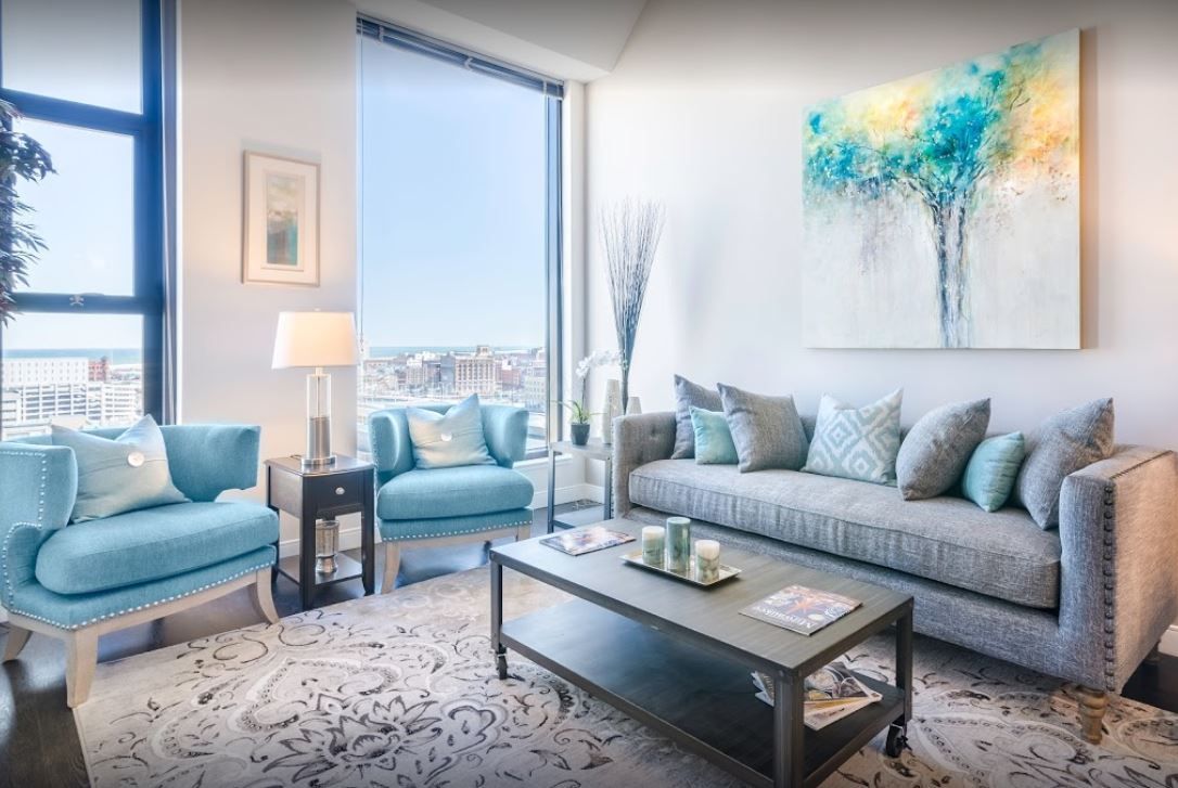 A living room with a couch , chairs , and a coffee table.