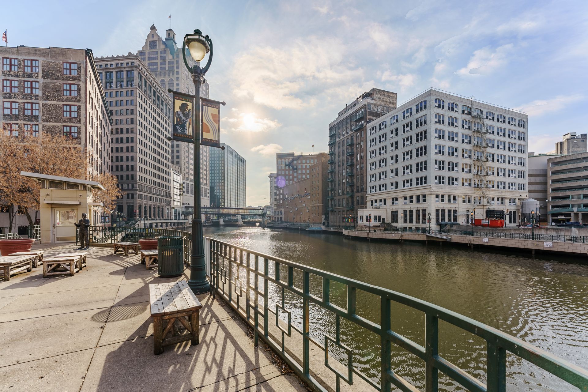 A river with buildings in the background and a bench in the foreground