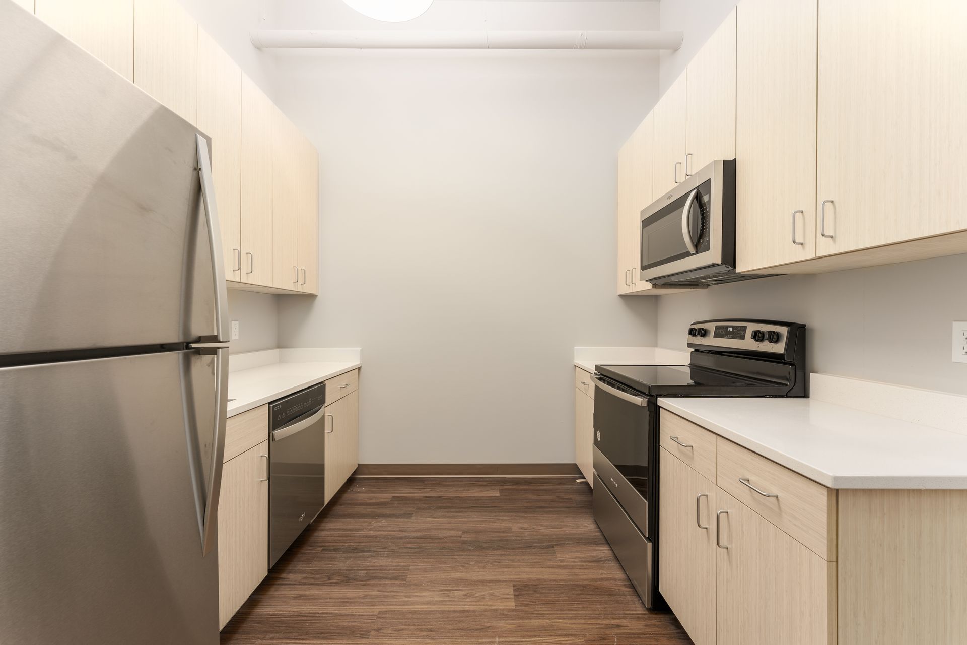 A kitchen with stainless steel appliances and wooden cabinets.