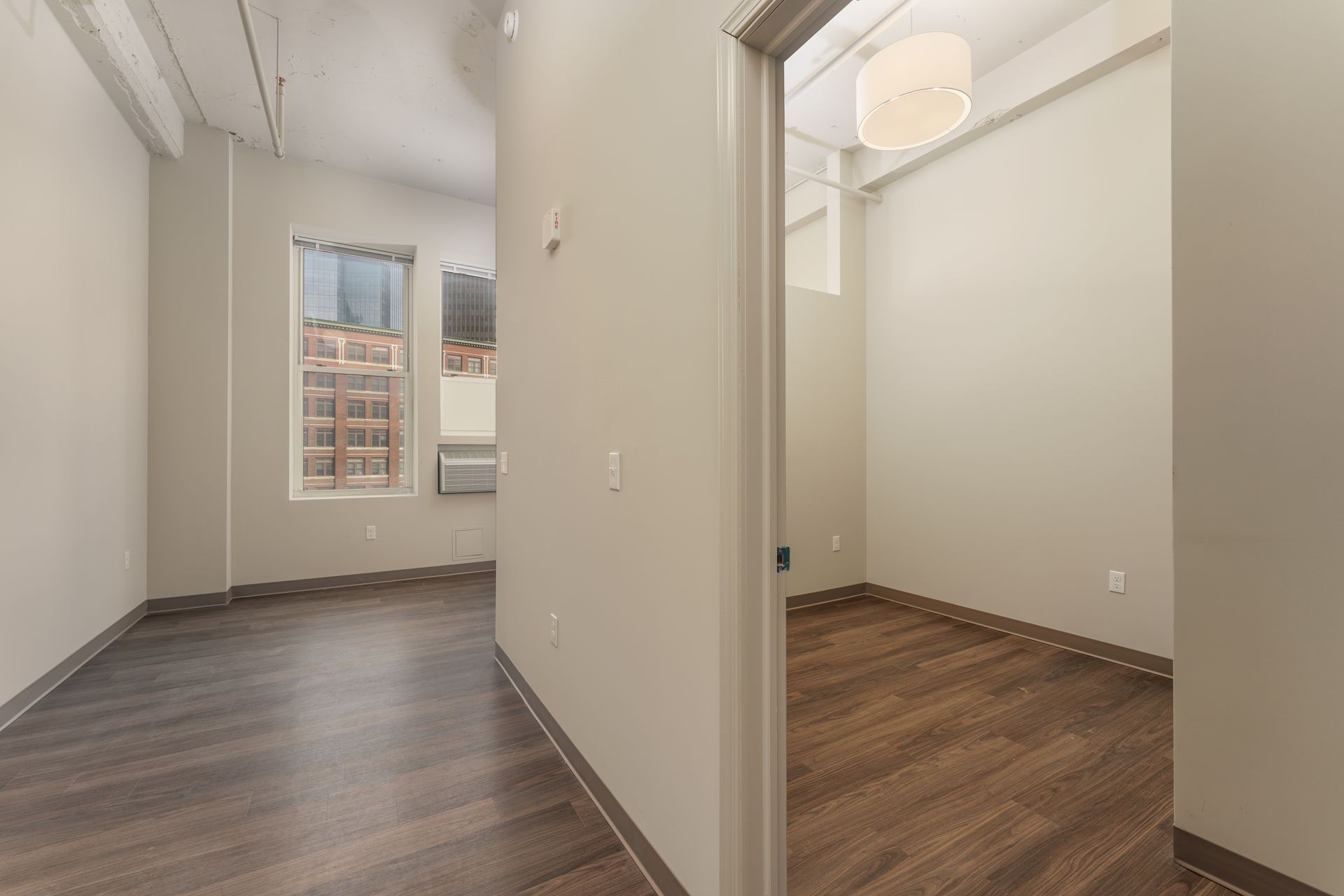 An empty room with hardwood floors and a window.
