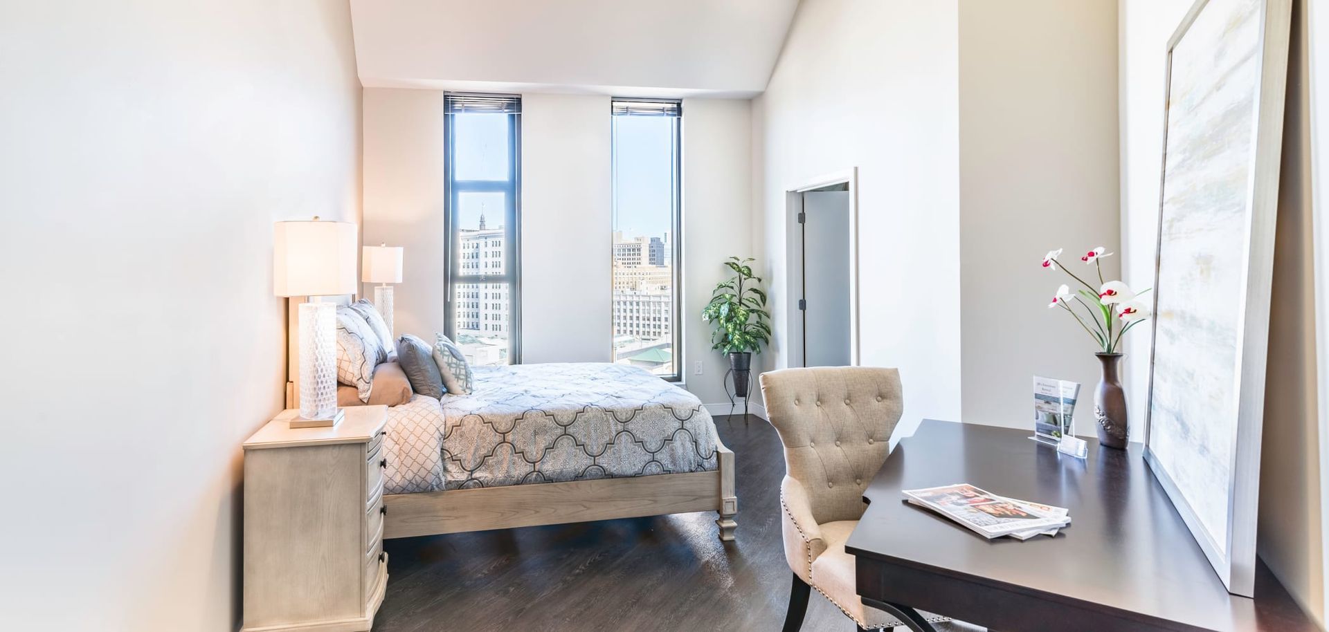 A bedroom with a bed , desk , chair and window.