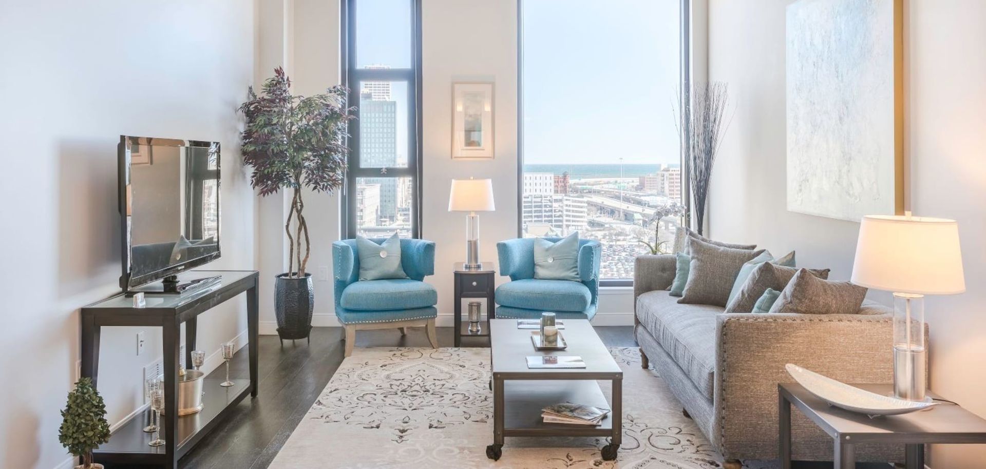 A living room with a couch , chairs , coffee table , and television.