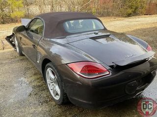 A porsche boxster convertible is parked on the side of the road