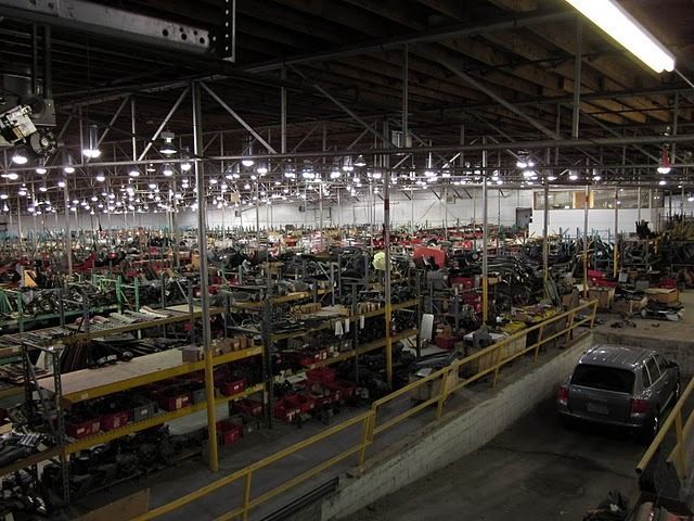 A large warehouse filled with lots of shelves and cars