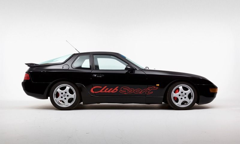 A black porsche 968 club sport is parked on a white surface.