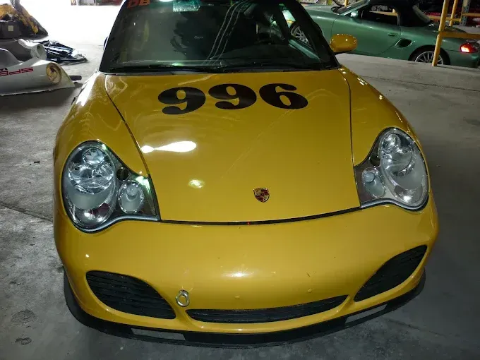 A yellow car with the number 996 on the hood