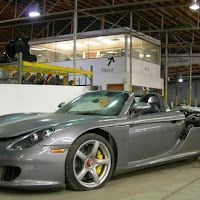 A gray sports car is parked in a garage.