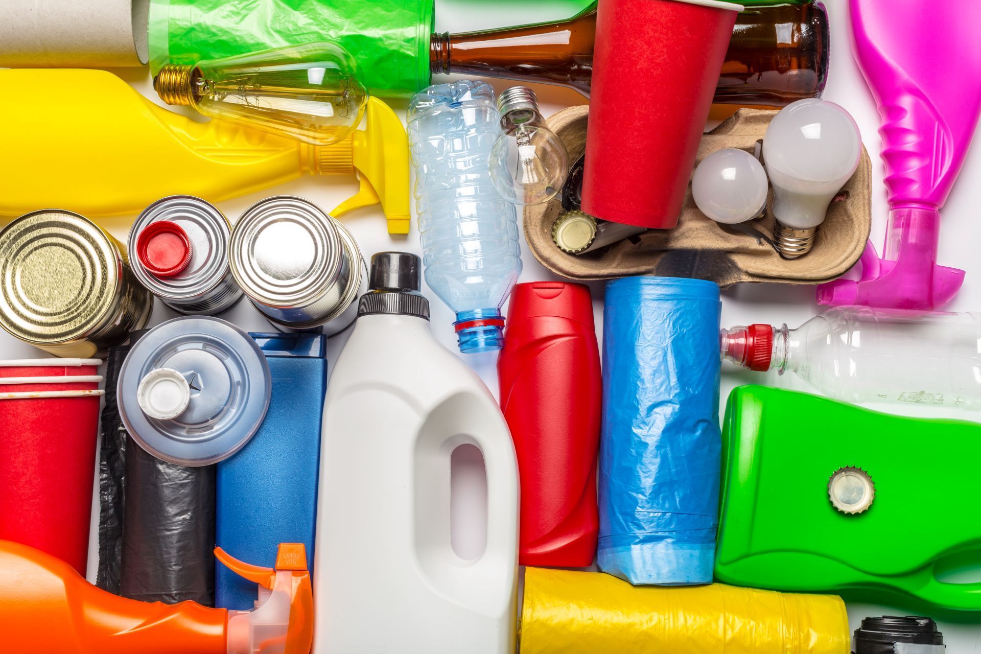 Assorted colorful plastic and metal recyclable containers and bottles piled together