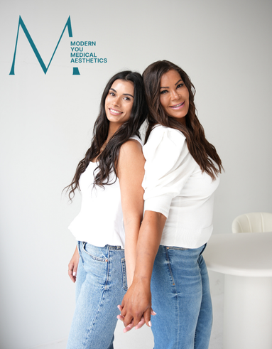 Two women are standing next to each other holding hands and smiling.