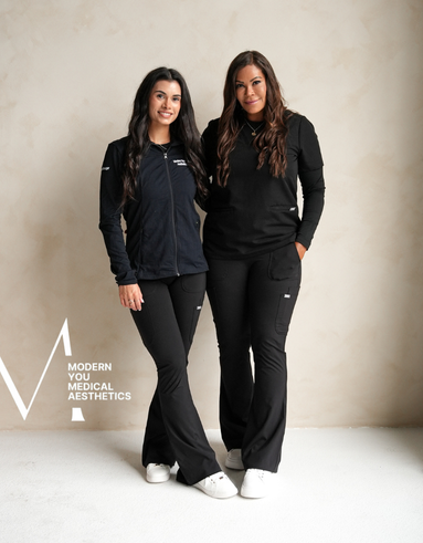 Two women are standing next to each other wearing black uniforms.