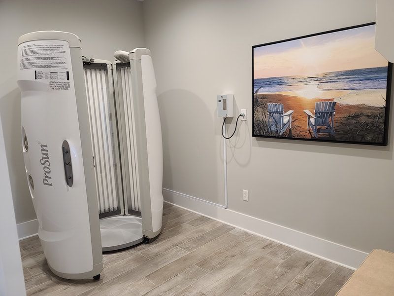 A room with a tanning booth and a picture on the wall.