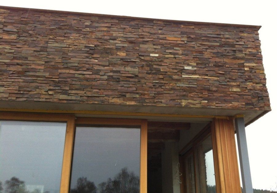 Okna z drewnianymi ramami pokryte okładziną kamienną.