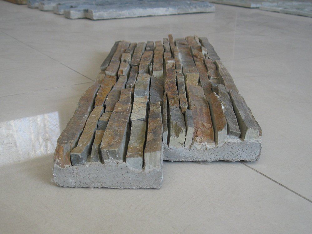 Płytka kamienna o różnych odcieniach beżu, brązu i szarości. Ułożona na szarym podłożu.