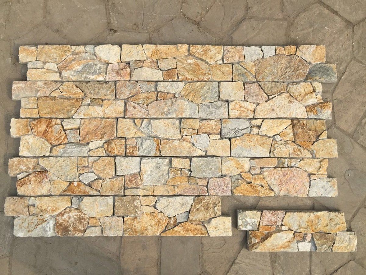 Panele z płytek kamiennych, różnych kształtów i rozmiarów, ułożone we wzór w odcieniach beżu, szarości i złota.