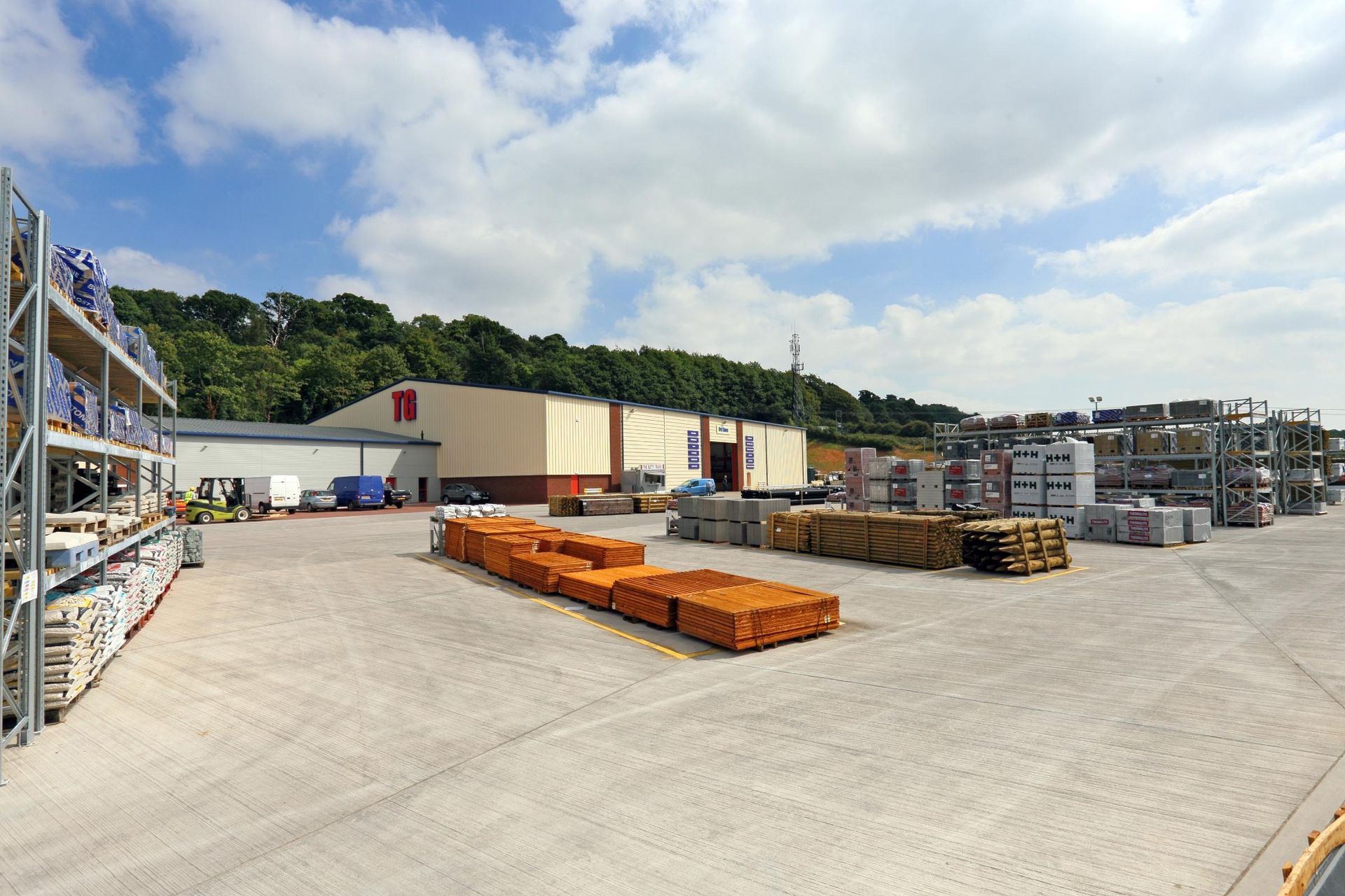 Żółta ceglana elewacja z oknami w czarnych ramach. Na ścianie zamontowana jest ciemna latarnia.