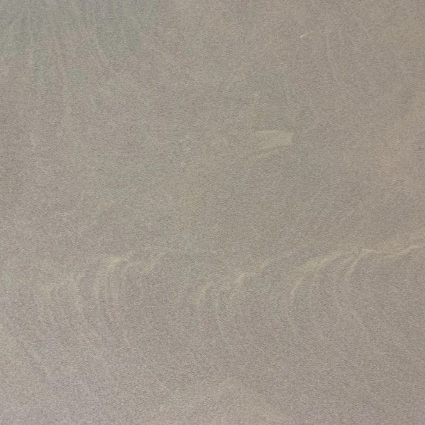 Beżowa, teksturowana powierzchnia z delikatnymi, jaśniejszymi, falistymi wzorami.