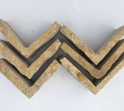 Sześć jasnobrązowych, ukośnych płytek przypominających cegłę, ułożonych w zygzakowaty wzór na białej powierzchni.