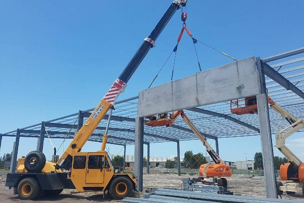 A mobile crane on site on the Sunshine Coast lifting a concrete frame - AMAC Cranes