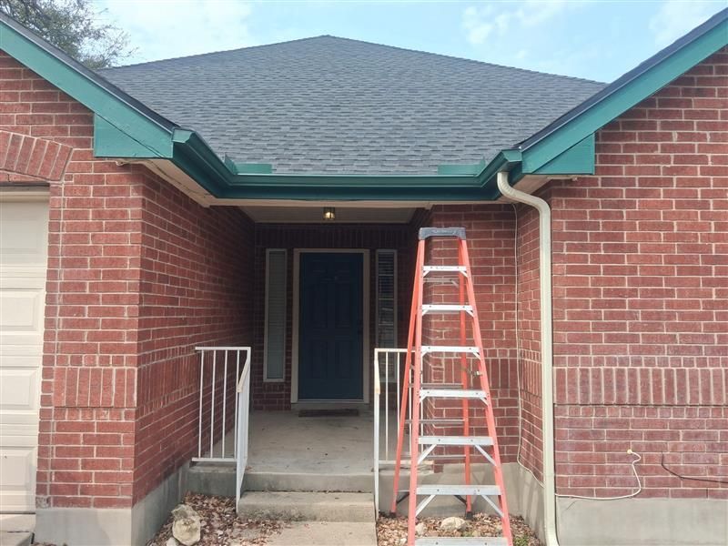 Brick house entrance with a red ladder on the porch under the front awning