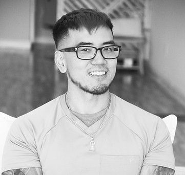 A black and white photo of a man wearing glasses and a shirt.