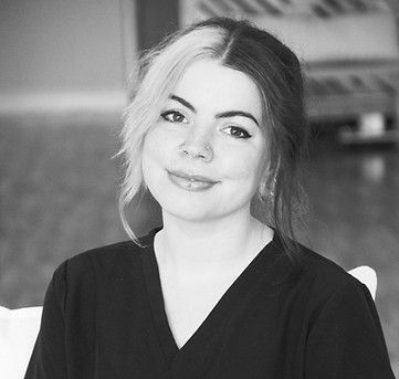 A black and white photo of a woman wearing a scrub top.