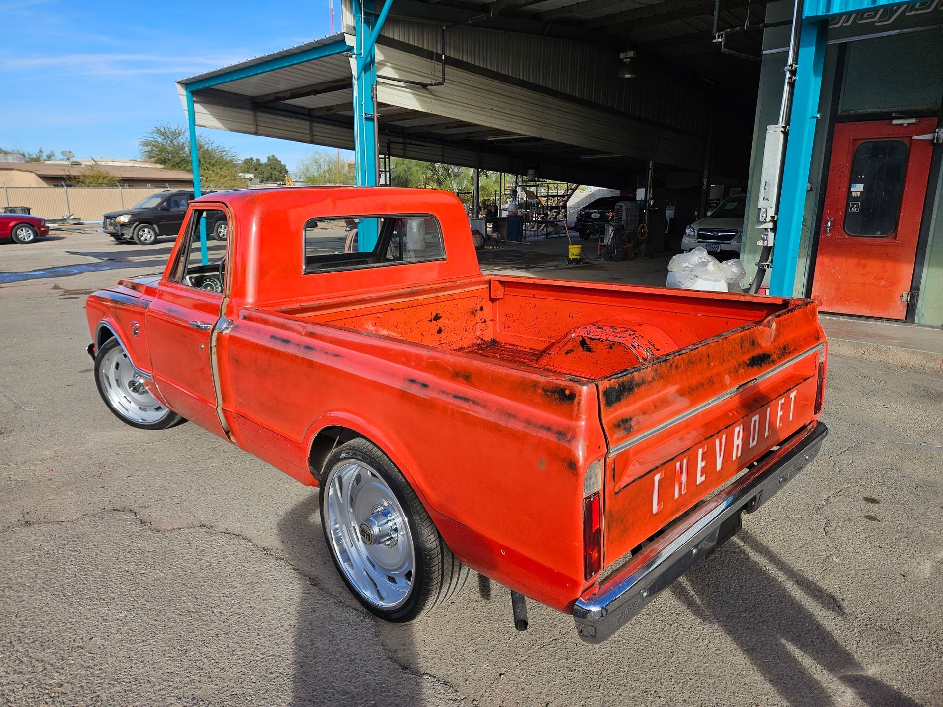 A red pickup truck is parked in front of a building.