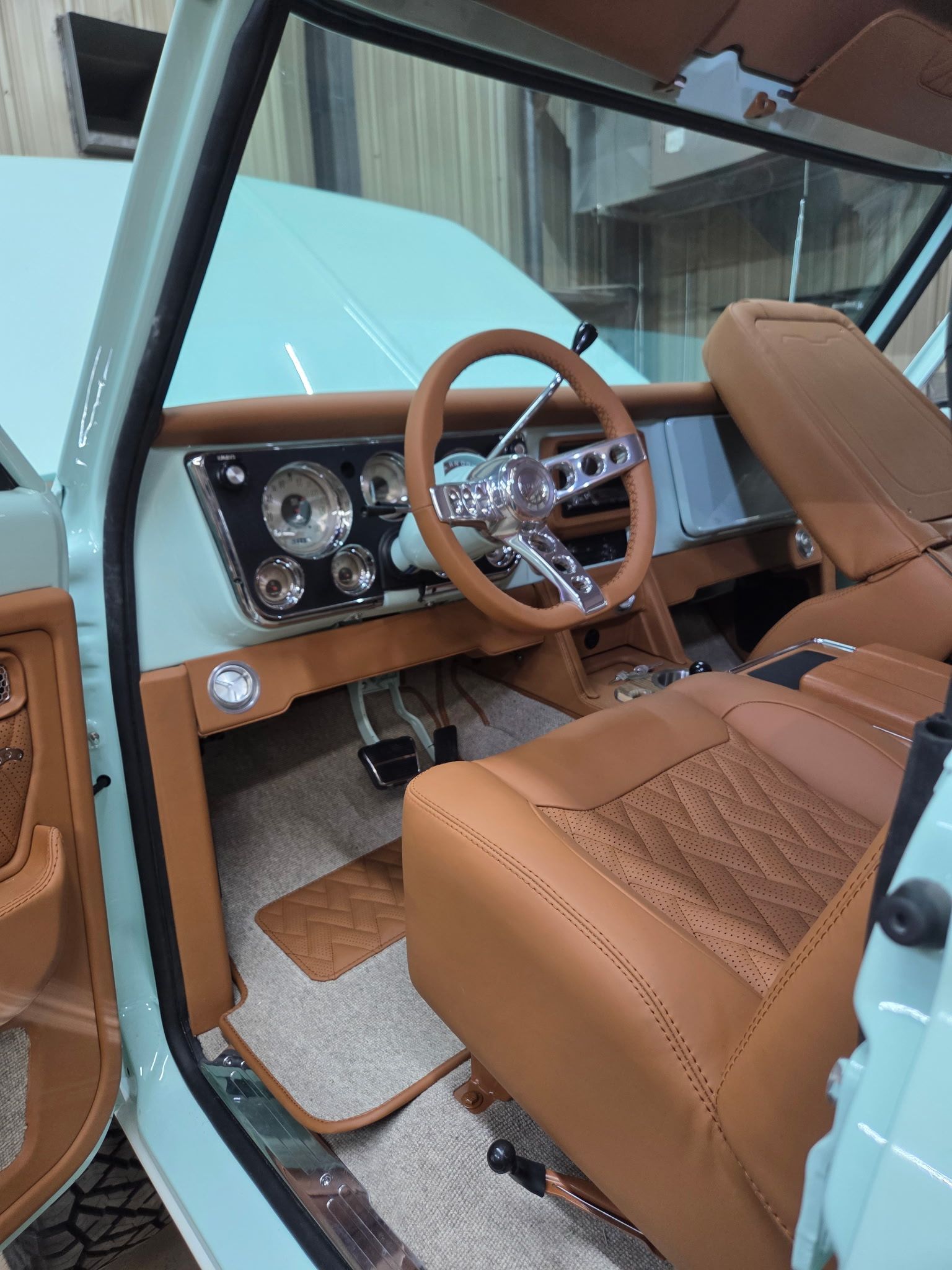 Classic light blue pickup truck interior with tan leather seats and steering wheel.