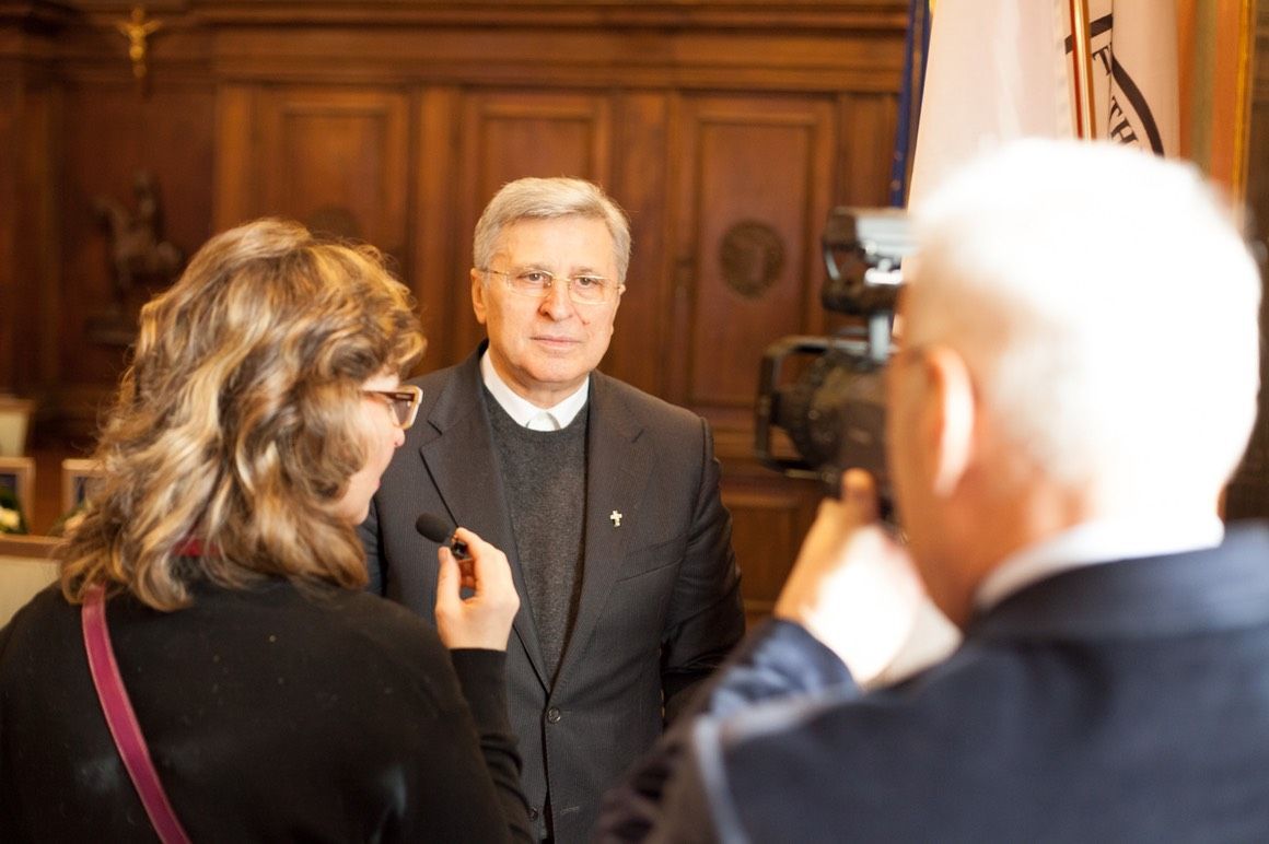 Un uomo in giacca e cravatta viene intervistato da una donna