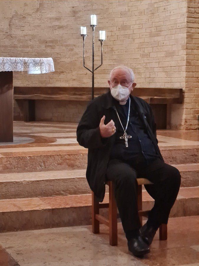 Un uomo che indossa una maschera è seduto in una chiesa