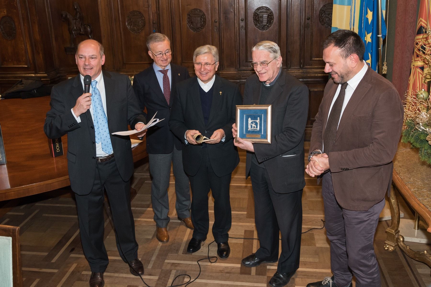 Un gruppo di uomini è in piedi uno accanto all'altro in una stanza.