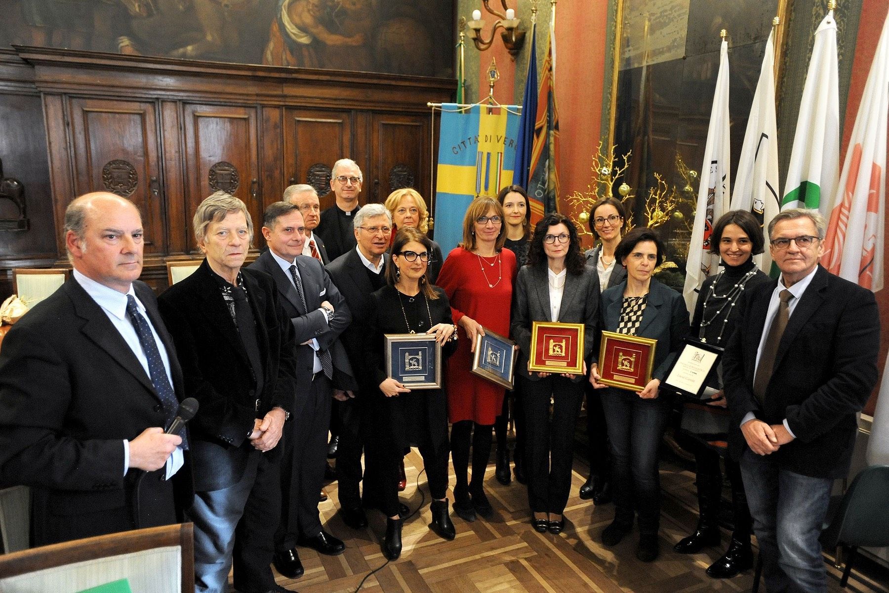 Un gruppo di persone in piedi in una stanza con in mano dei premi