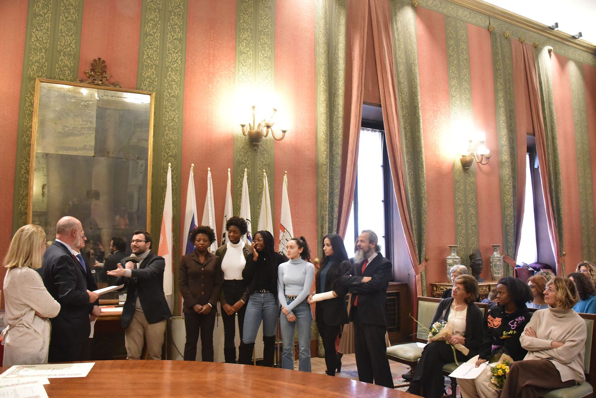 Un gruppo di persone è in piedi attorno a un tavolo in una stanza.