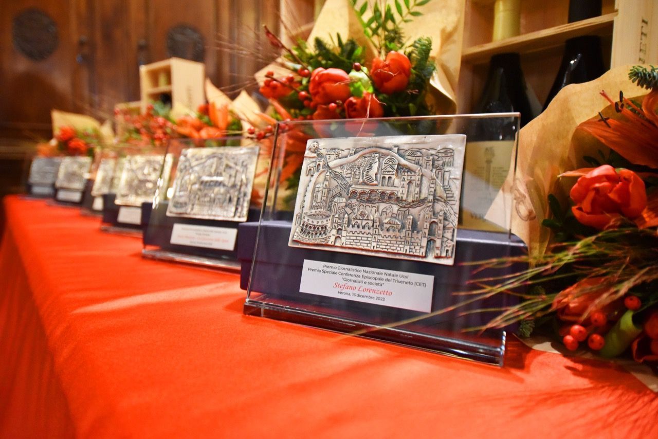 Una fila di trofei e fiori su un tavolo.