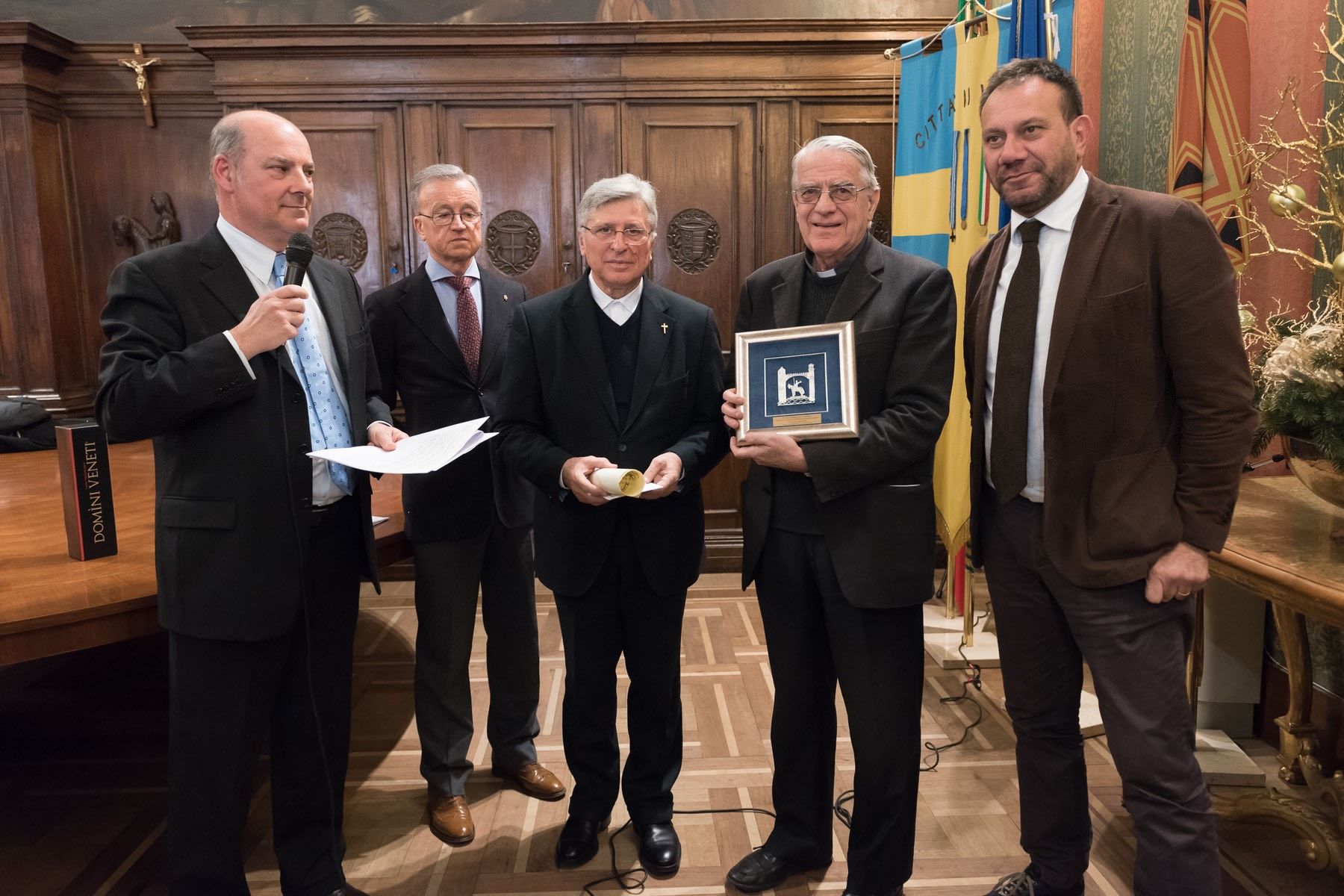 Un gruppo di uomini è in piedi uno accanto all'altro in una stanza.