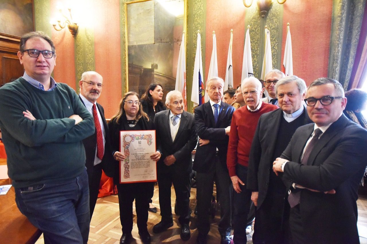 Un gruppo di persone è in una stanza con le bandiere.