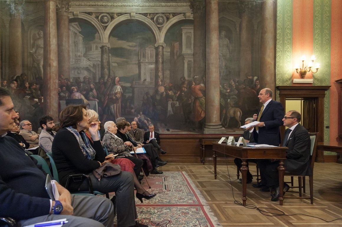 Un uomo sta facendo una presentazione a un gruppo di persone in una stanza.