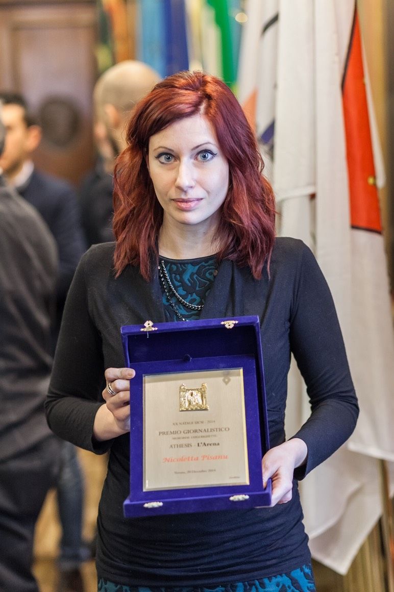 Una donna dai capelli rossi tiene in mano una placca viola