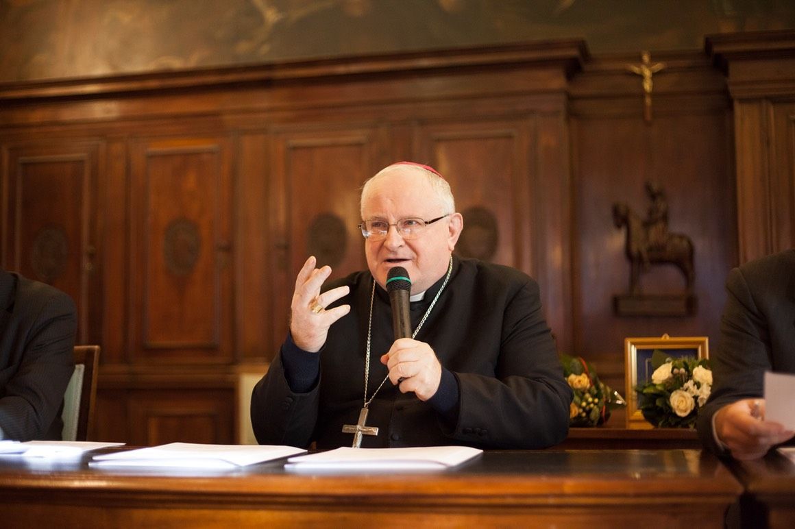 Un uomo è seduto a un tavolo e parla al microfono.