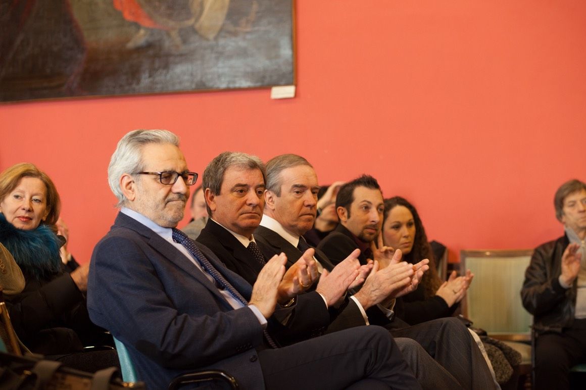 Un gruppo di persone è seduto in una stanza e batte le mani.