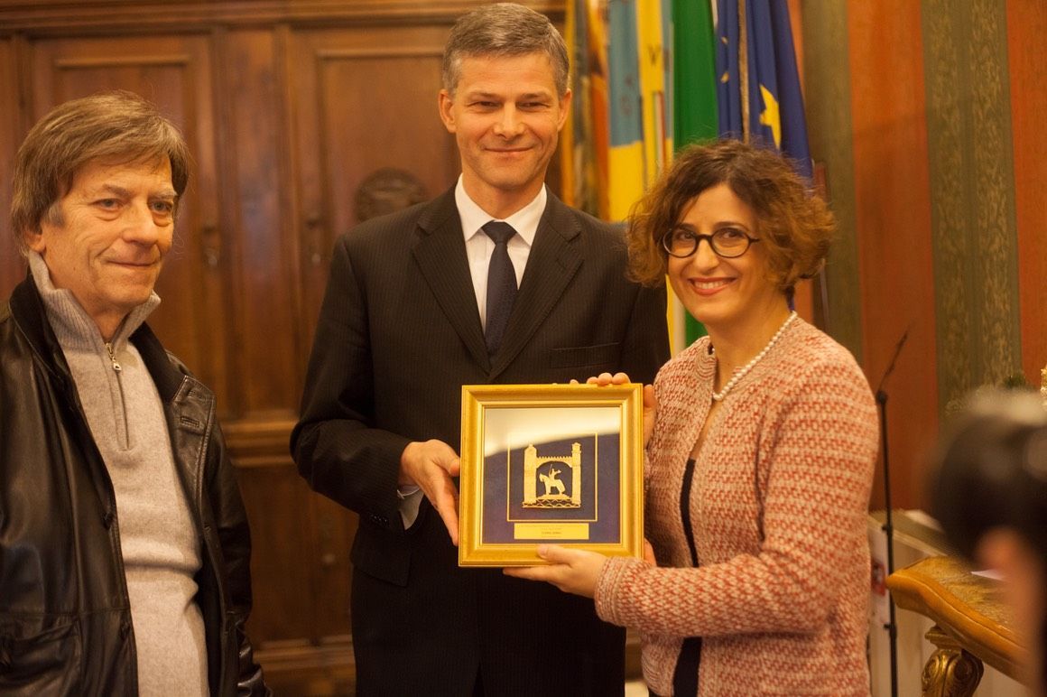 Un uomo e una donna sono in piedi uno accanto all'altro con in mano una foto incorniciata.