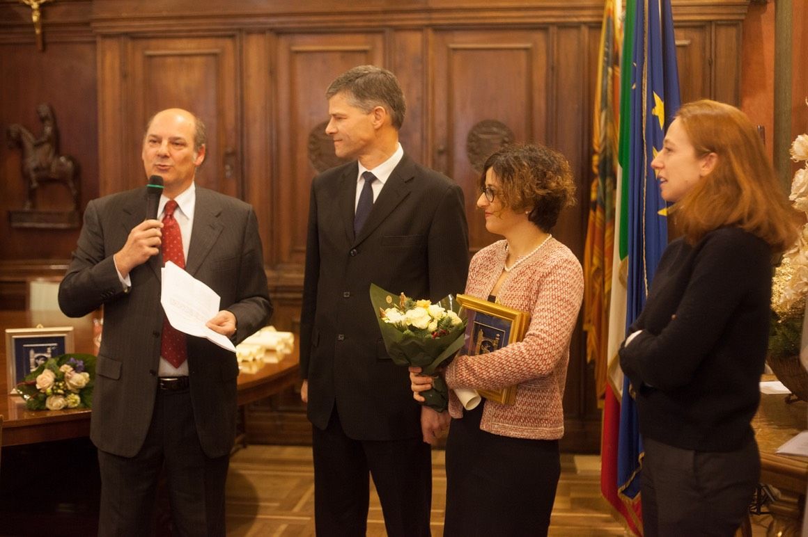 Un uomo in giacca e cravatta sta tenendo un discorso a un gruppo di persone