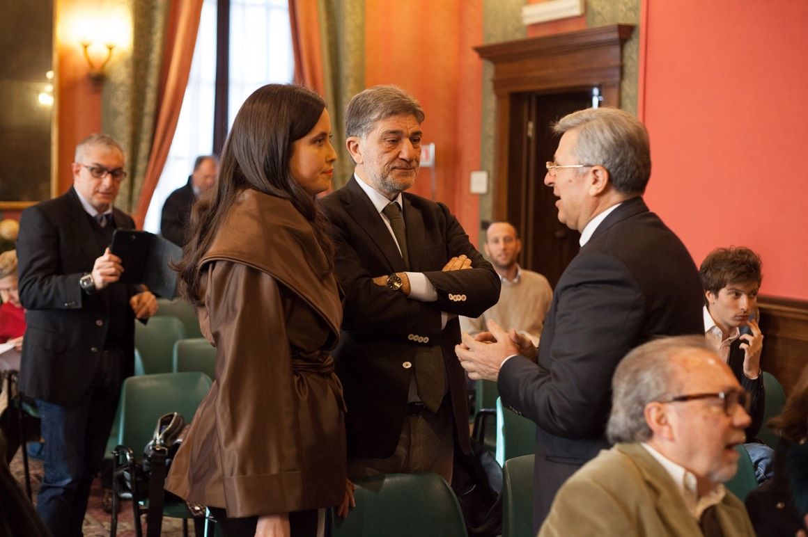 Un gruppo di persone è in una stanza e parla tra loro.