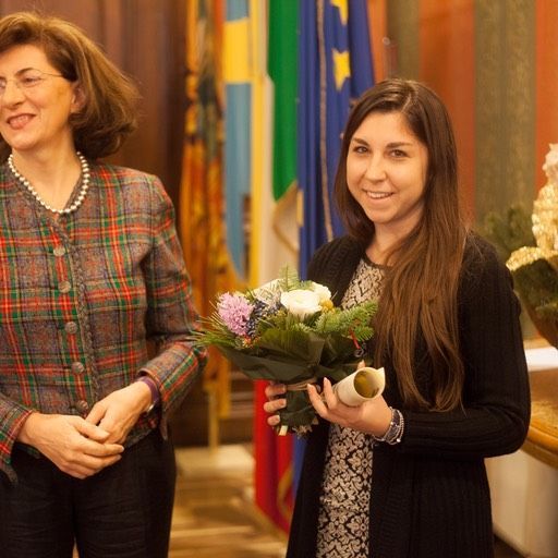 Due donne in piedi una accanto all'altra con in mano un mazzo di fiori