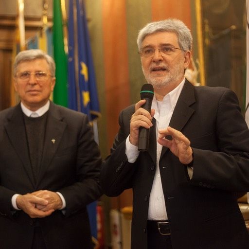 Un uomo in giacca e cravatta parla al microfono