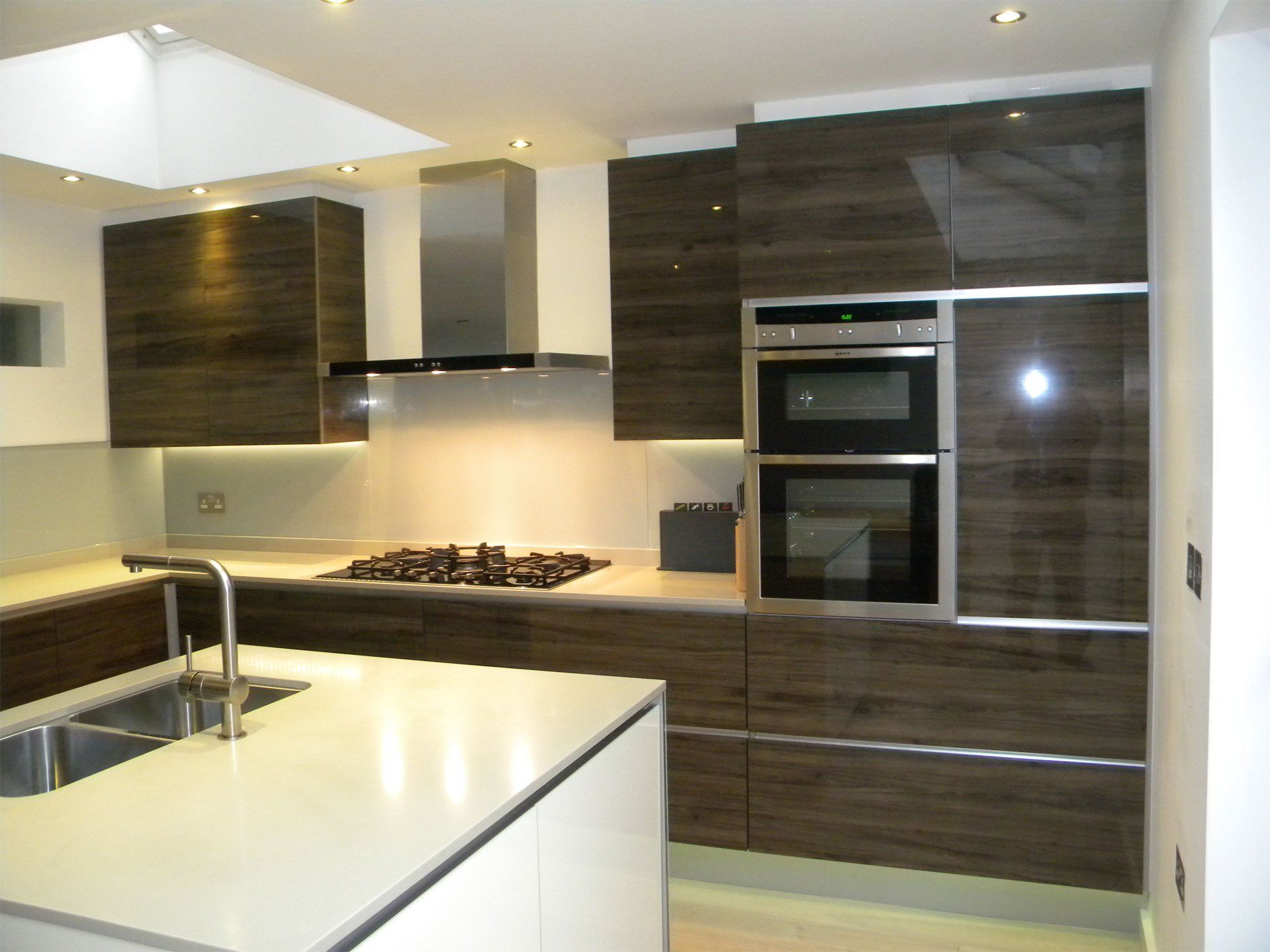 A Kitchen redesign with walnut cupboards and white counters.